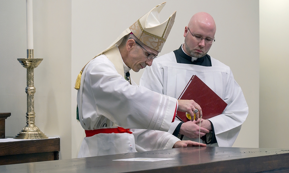 Bishop James Ruggieri uses chrism to anoint the altar.