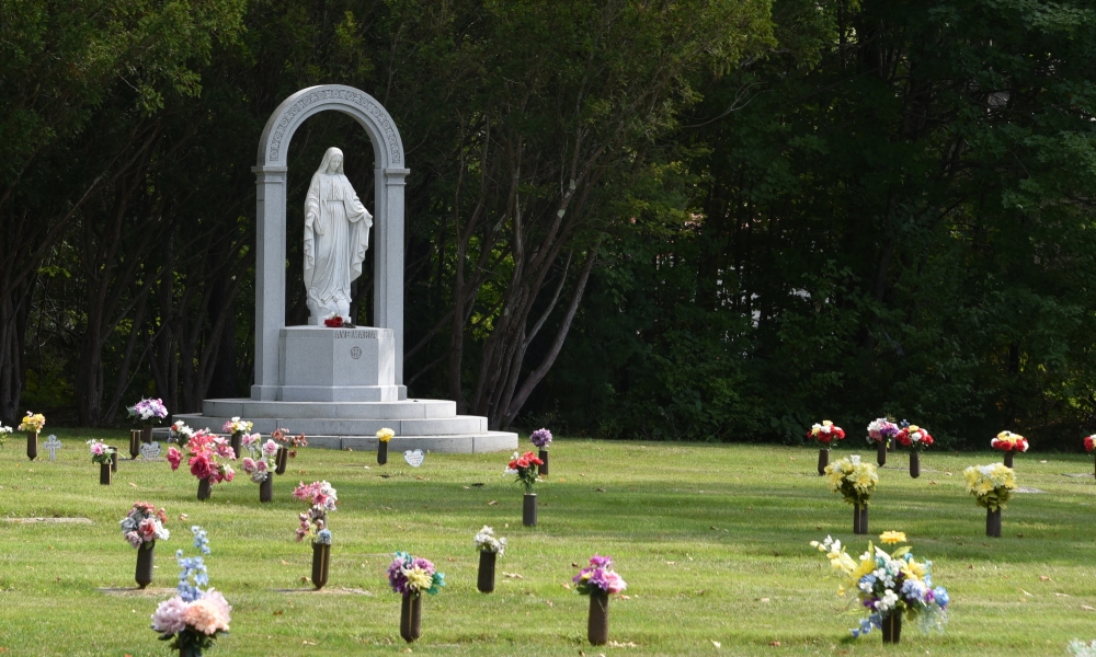 Statue of the Blessed Mother at a cemetery.